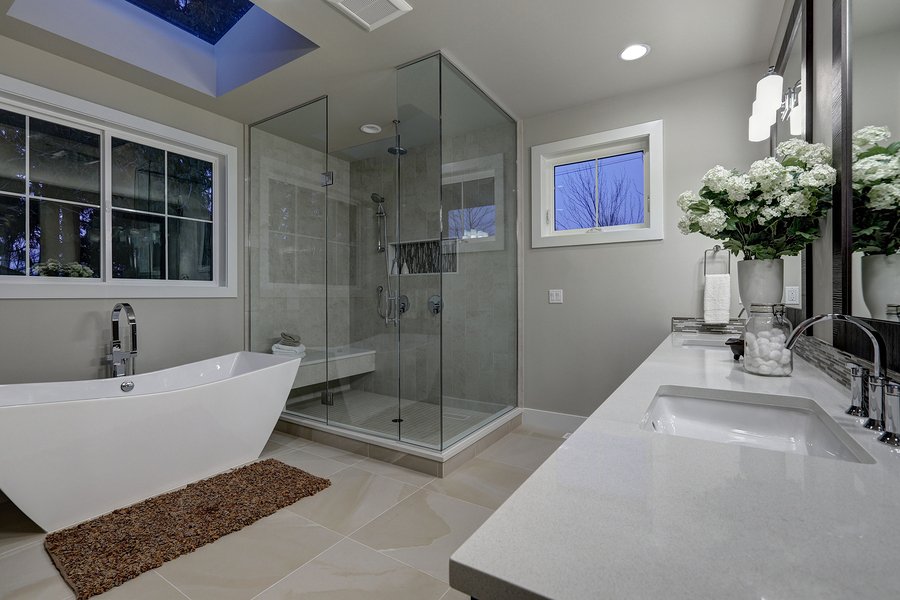 Amazing gray master bathroom with large glass walk-in shower freestanding tub and skylights on the ceiling. Northwest USA